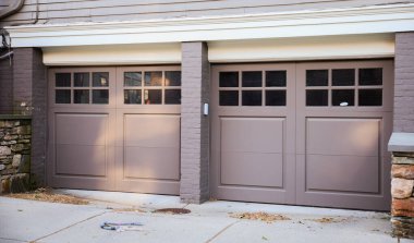 Garajda kapısı olan turuncu tuğlalı kapıların dikey görüntüsü.