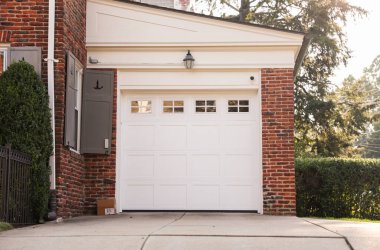 Beyaz tuğla kapılı ve kırmızı kapılı garajın girişi.