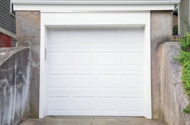 Beyaz garajlı beyaz metal kapı ve gri metal garaj..