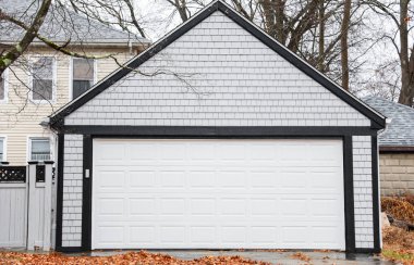 Banliyö evindeki siyah garaj. Tuğla duvar ve metal kapılı.