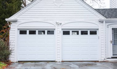 Beyaz tuğla duvarlı ve gri kapılı garaj.