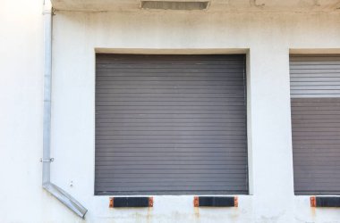 Beyaz arka planda beyaz panjurlu eski pencere.