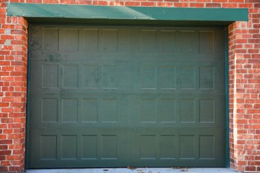 Yeşil kapısı olan kahverengi bir tuğla kapı.