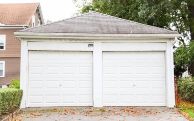 Kırmızı tuğlalı çatısı olan beyaz garaj