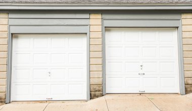 Evin önünde beyaz ve siyah kapılar ve kapılar var.