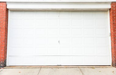 Beyaz ve siyah tuğlalı kapısı olan garaj kapıları