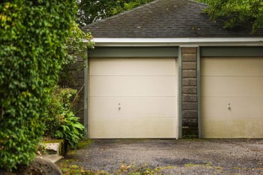 Metal kapısı ve kapısı olan garaj kapısının önünde..