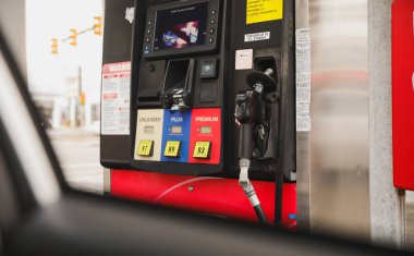 Benzin istasyonunda kırmızı benzin pompası olan bir benzin istasyonu