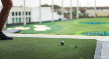 Kulüpte golf oynayan genç bir kadın.