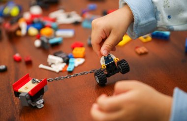 Küçük çocuk oyuncak arabalarla oynuyor.