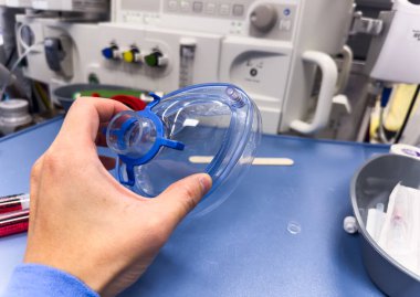 Doktor, hasta için tıbbi bir maske tutuyor.