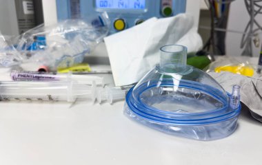 Koronavirüs salgını sırasında hastanede bir şırıngayla tıbbi maskenin dikey görüntüsü.