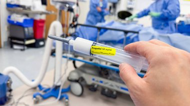 Hastane ortamında steril bir yüzey üzerinde duran temiz sıvıyla dolu tıbbi bir şırınganın yakın çekimi. Sağlık, ilaç ve tedaviyi sembolize eder. Hassasiyet, bakım ve iyileşmeyi temsil eder.