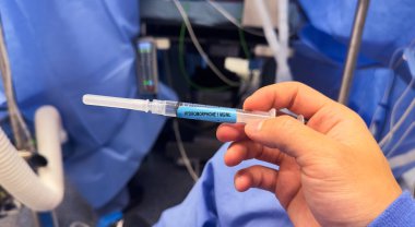 Hastane ortamında steril bir yüzey üzerinde duran temiz sıvıyla dolu tıbbi bir şırınganın yakın çekimi. Sağlık, ilaç ve tedaviyi sembolize eder. Hassasiyet, bakım ve iyileşmeyi temsil eder.