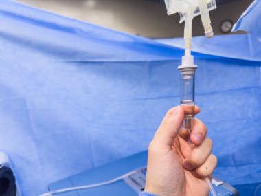 Ameliyathanede şırıngayla şırınga tutan doktorun eli.