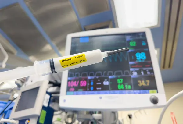 stock image close-up of a medical syringe filled with clear liquid, resting on a sterile surface in a hospital environment. Symbolizing healthcare, medicine, and treatment, it represents precision, care, and healing