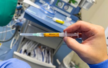 Hastane ortamında steril bir yüzey üzerinde duran temiz sıvıyla dolu tıbbi bir şırınganın yakın çekimi. Sağlık, ilaç ve tedaviyi sembolize eder. Hassasiyet, bakım ve iyileşmeyi temsil eder.