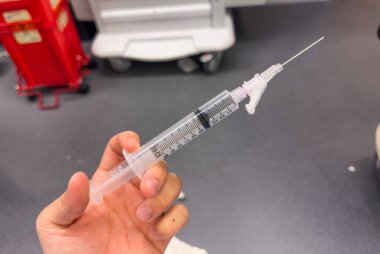 Bir adam şırıngayı bir doktorun elinde tutuyor. Koronavirüse karşı aşı kavramı. Kapat.