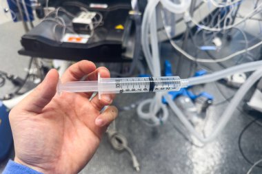 Hastane ortamında steril bir yüzey üzerinde duran temiz sıvıyla dolu tıbbi bir şırınganın yakın çekimi. Sağlık, ilaç ve tedaviyi sembolize eder. Hassasiyet, bakım ve iyileşmeyi temsil eder.