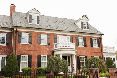 Bahçedeki beyaz tuğlalı ev.