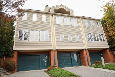 Tuğla duvarları ve kahverengi kapıları olan modern bir ev.