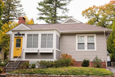 Tuğla evin önünde geniş pencereli güzel bir ev.