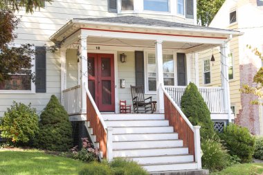 Kırmızı tuğlalı eski bir evin beyaz ahşap kapısı.