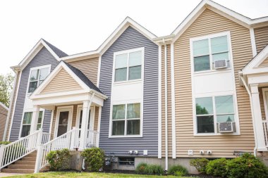 Yeni bir sokakta iki penceresi olan modern bir ev.