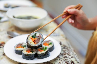 Asyalı şef sushi tutuyor.