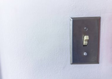 Beyaz bir duvarda elektrik düğmesi