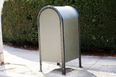 Bahçedeki metal bir posta kutusu.