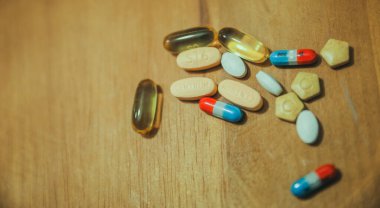 pills and tablets on a wooden table.