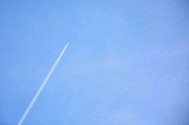 Mavi bulutlu bir arka planda beyaz bir uçak