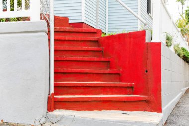 Arka planda beyaz bir duvarı ve merdiveni olan eski boyalı bir kapı.