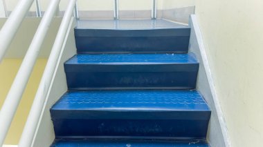 Mavi kiremitleri ve metal parmaklıkları olan merdiven.