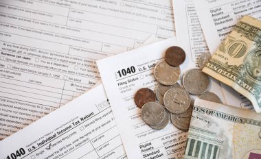 Amerikan vergi formu, Amerikan doları, hesap makinesi, vergi formu ve kalem ahşap bir masa arkasında..