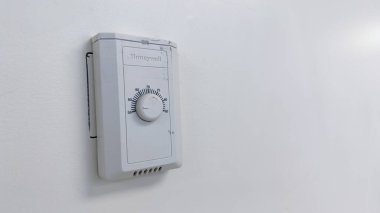 Dairedeki duvarda beyaz elektrik alarmı var.