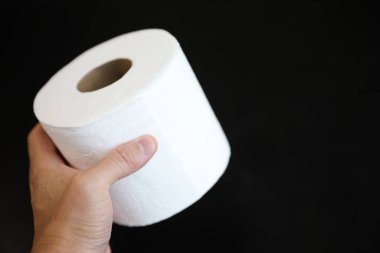 Tuvalet kağıdı beyaz arka planda bir elde yuvarlanıyor..