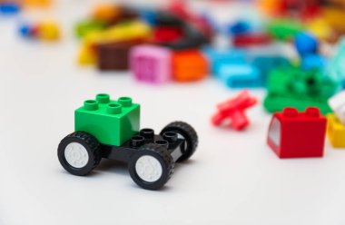 Beyaz arkaplanda renkli oyuncak plastik bloklar.