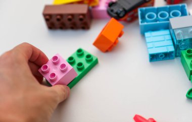 Çocuğun elinde plastik oyuncak blokları.