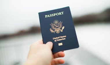Pasaportu beyaz arka plandaki bir adamın elinde.