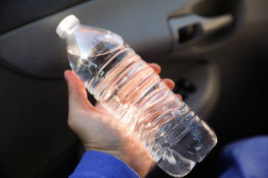 Bir şişe maden suyu ile el.