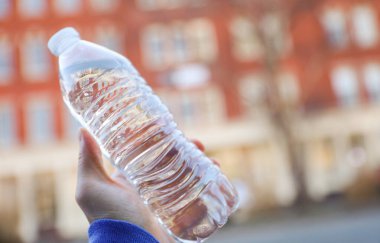 Plastik su şişesi kadınların elinde, yaklaşın.