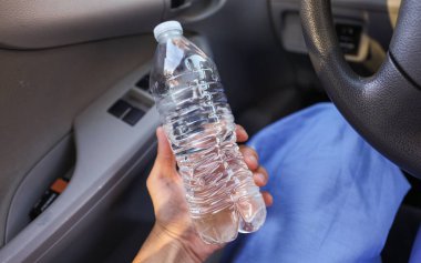 Arabayla el ele tutuşan su şişesi