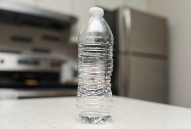 Boş plastik şişe, ahşap masada içmek için.
