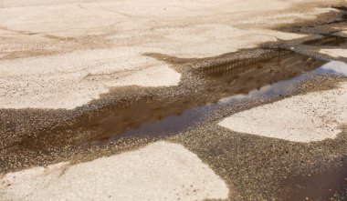 Asfalt yol ve su birikintisiyle çatırdıyor