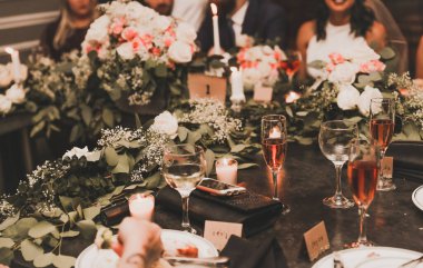 Güzel çiçekleri olan bir düğün masasının dikey görüntüsü.