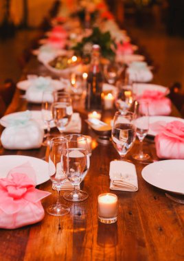 Mum ve çiçeklerle düğün masası süslemesi.