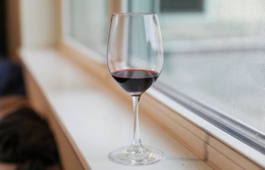 Pencere kenarında bir kadeh şarap, yakın plan.