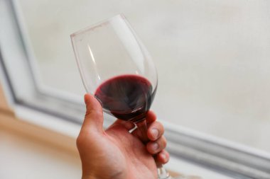 Masadaki bardakta kırmızı şarap var..